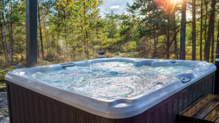 Steaming outdoor hot tub surrounded by trees