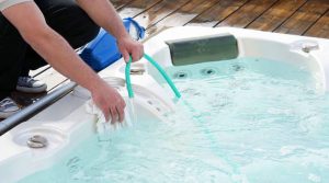 Person scrubbing the inside of a hot tub