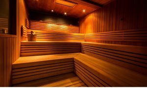 Wood-paneled indoor sauna with tiered seating and warm lighting