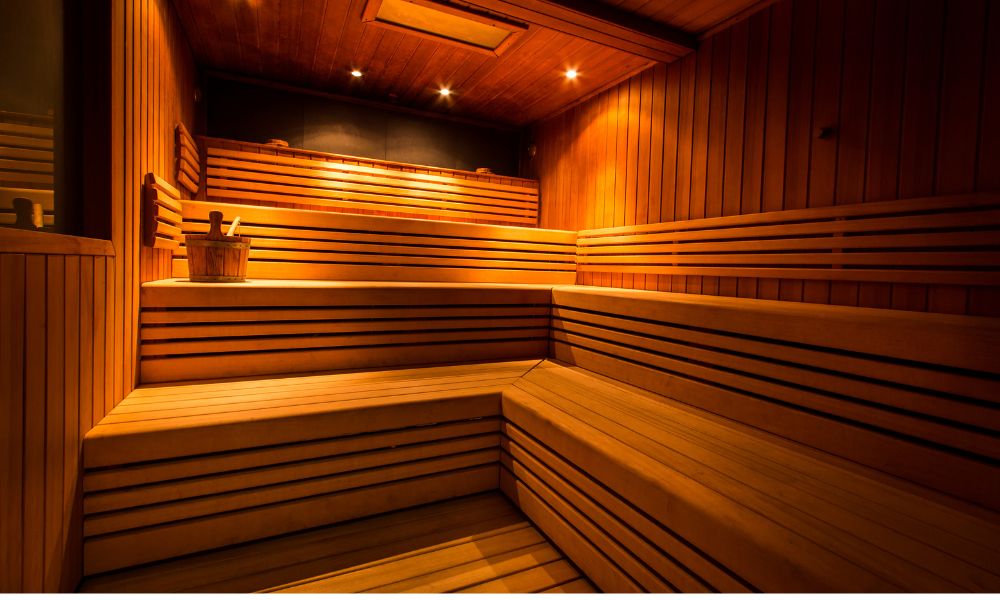 Interior wooden sauna with tiered seating and warm lighting