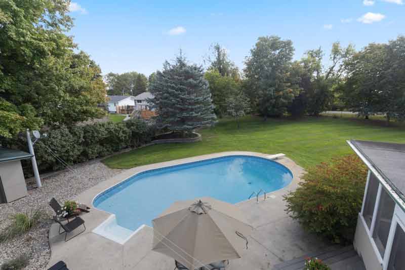 Backyard with an inground pool and surrounding lawn